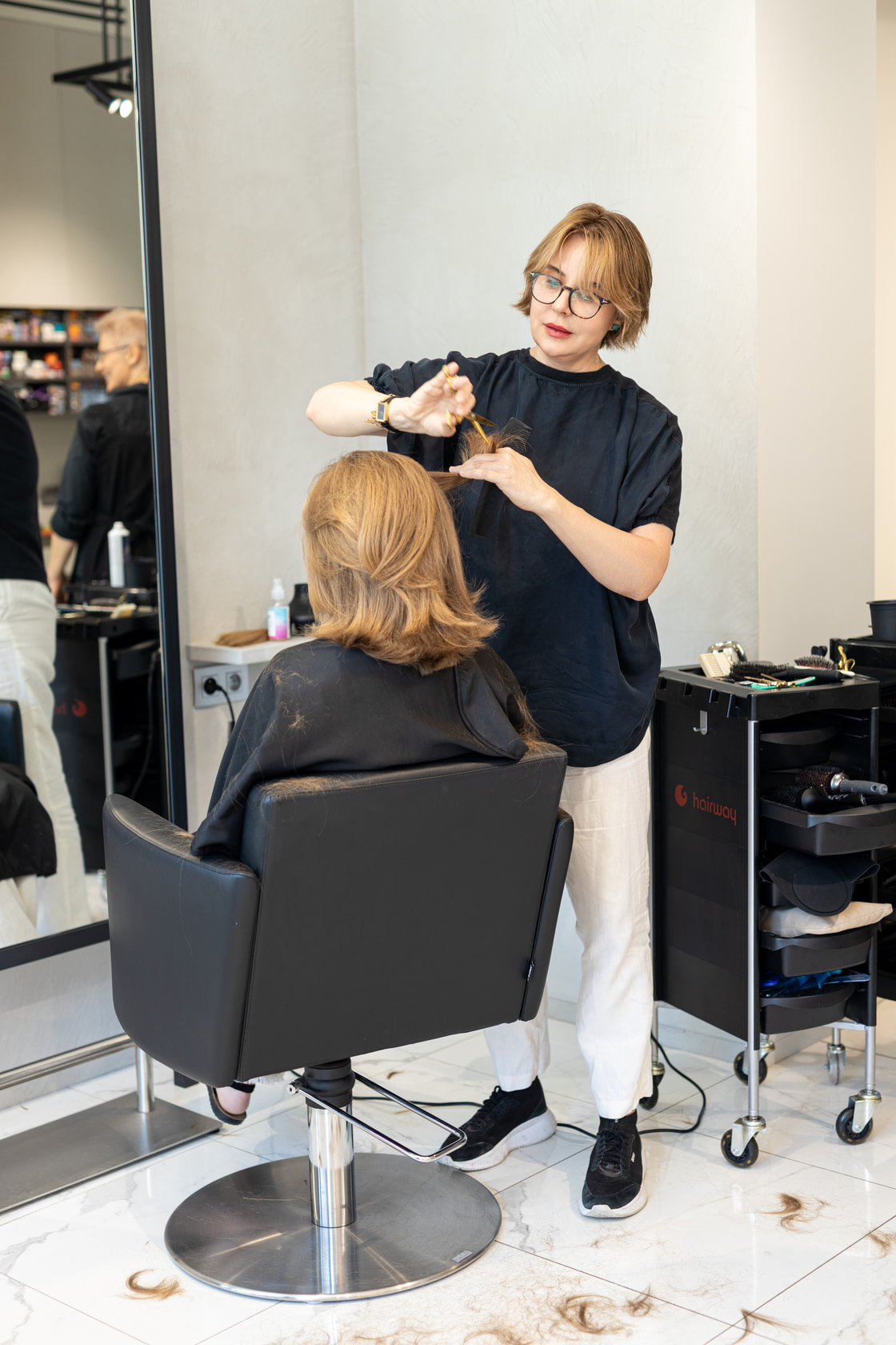 Wide view of the salon floor with a stylist at work